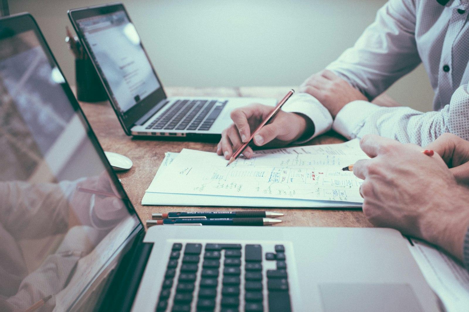 Patient records and a laptop on a practice meeting table